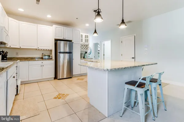a kitchen with stainless steel appliances granite countertop a refrigerator and a stove top oven