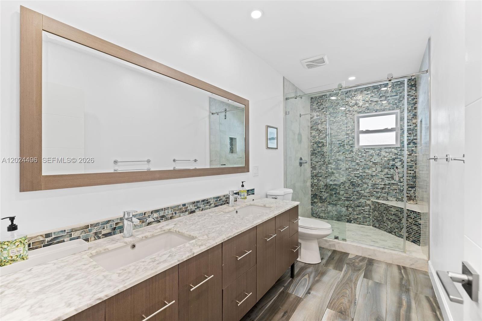 6875 North Cartee Road Palmetto Bay, FL 33158 - Photo 29 of 42 a bathroom with a bathtub double vanity sink and a mirror