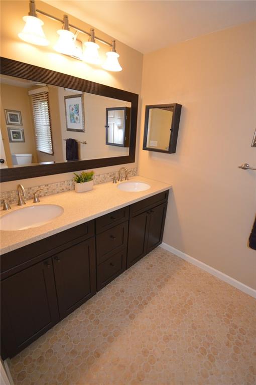 107 Yorktown Road Canonsburg, PA 15317 - Photo 19 of 25 Hall bath features an updated double vanity, countertop, fantastic backsplash, framed mirror and perfect lighting. Updated ceramic tile flooring and newer tub surround with built-in shelving,