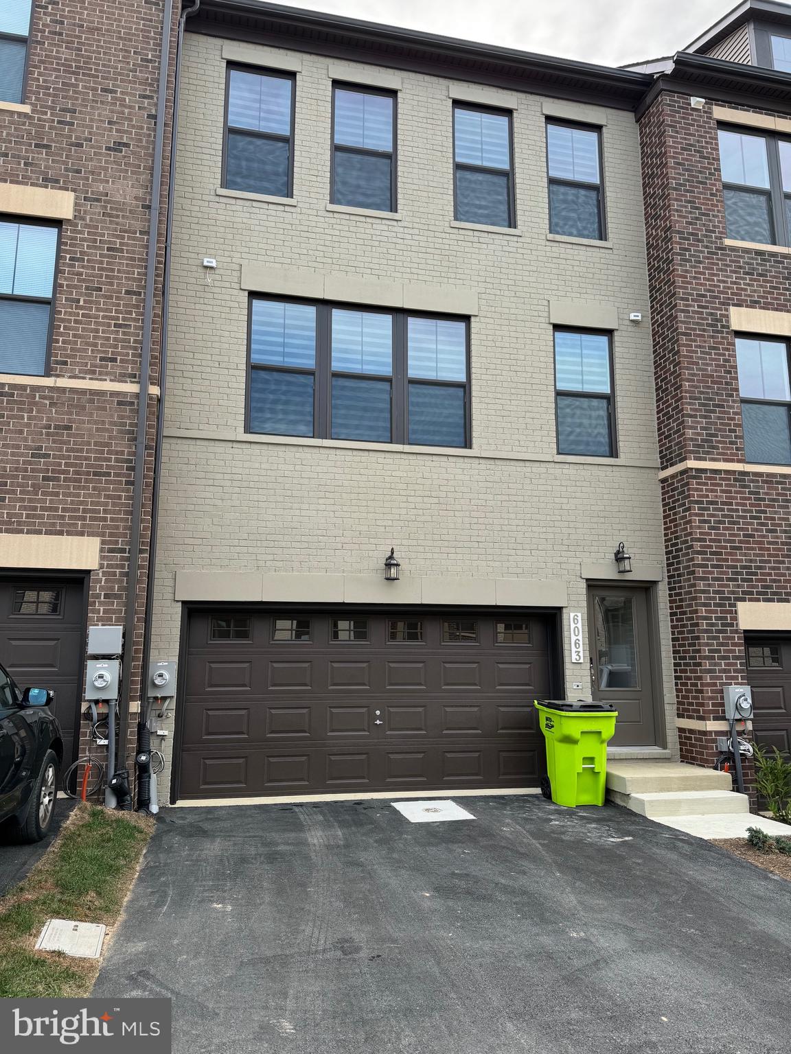 6063 Soho Way Hyattsville, MD 20782 - Photo 2 of 16 a front view of a building with glass windows and garage