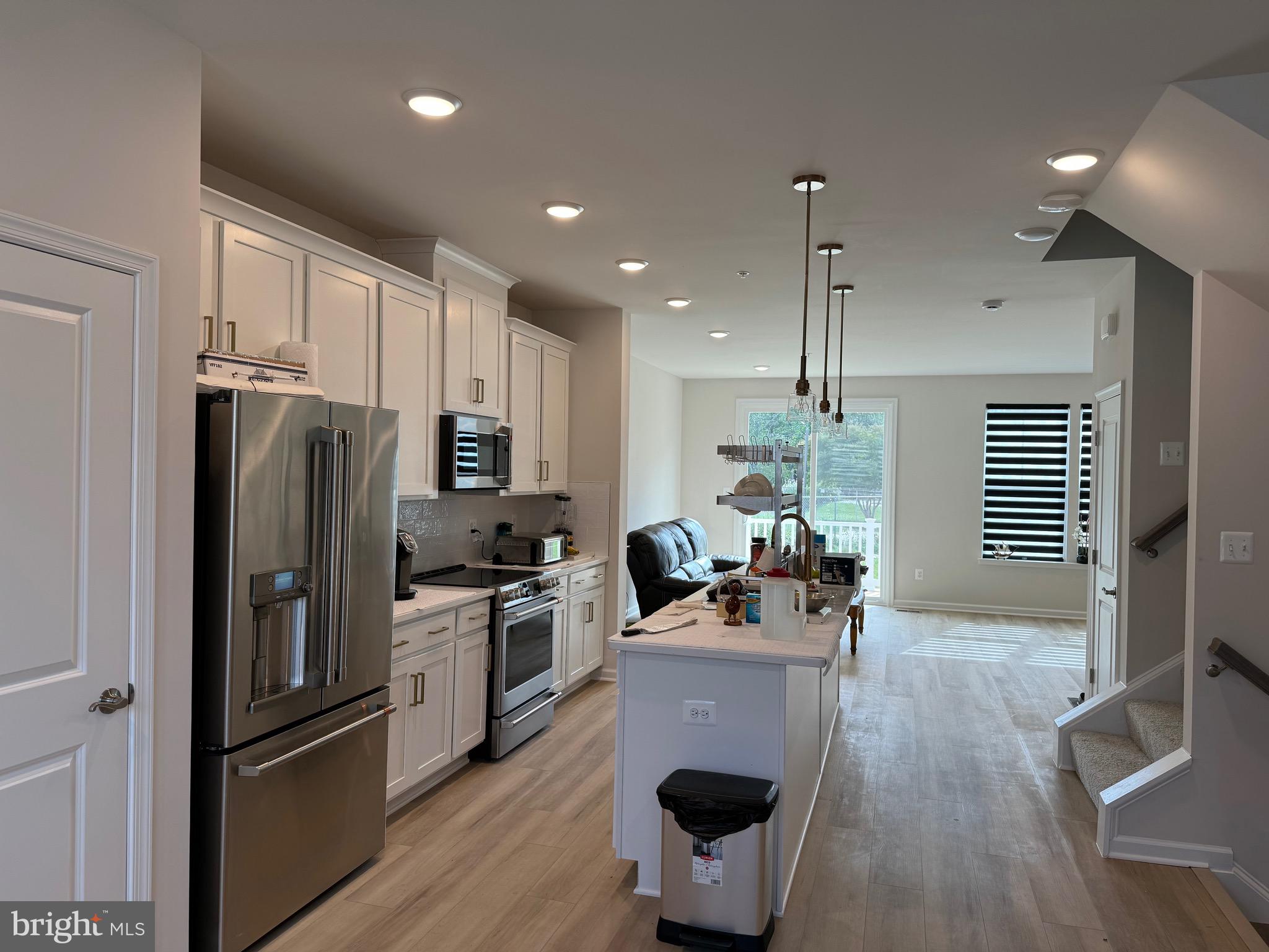 6063 Soho Way Hyattsville, MD 20782 - Photo 4 of 16 a kitchen with kitchen island a large counter top space appliances and wooden floor