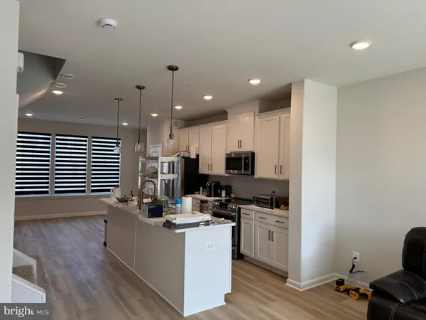 a kitchen with kitchen island sink cabinets and appliances