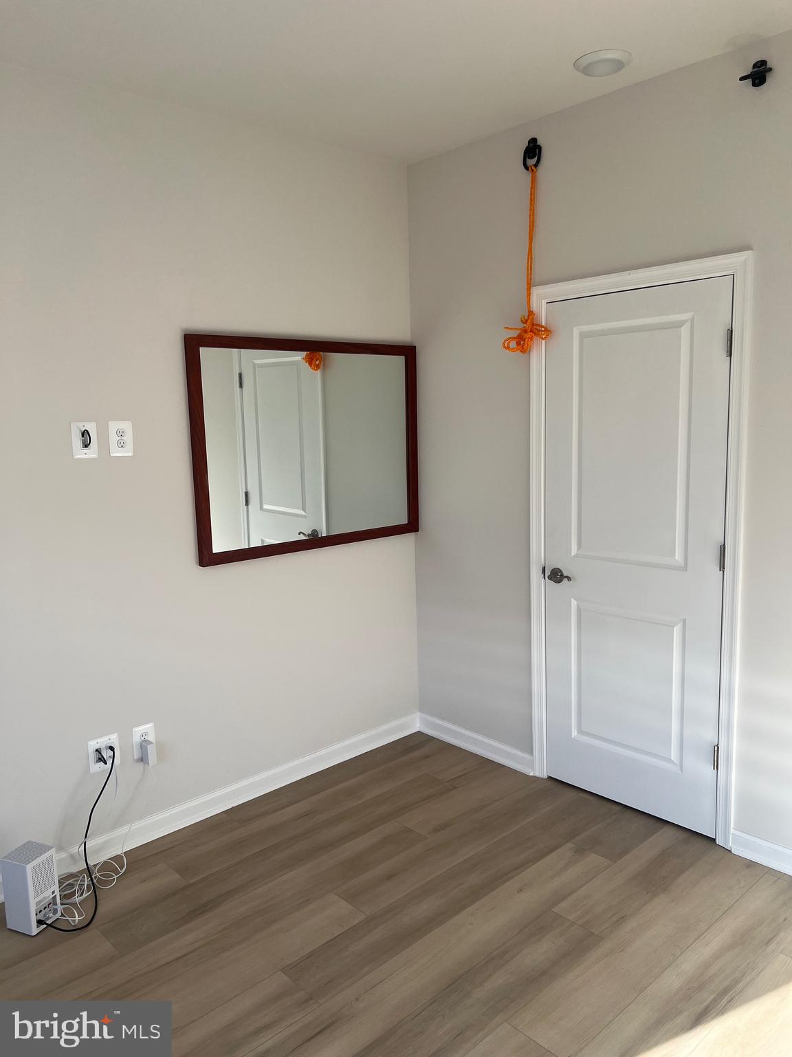 6063 Soho Way Hyattsville, MD 20782 - Photo 7 of 16 a view of an empty room with wooden floor and a mirror