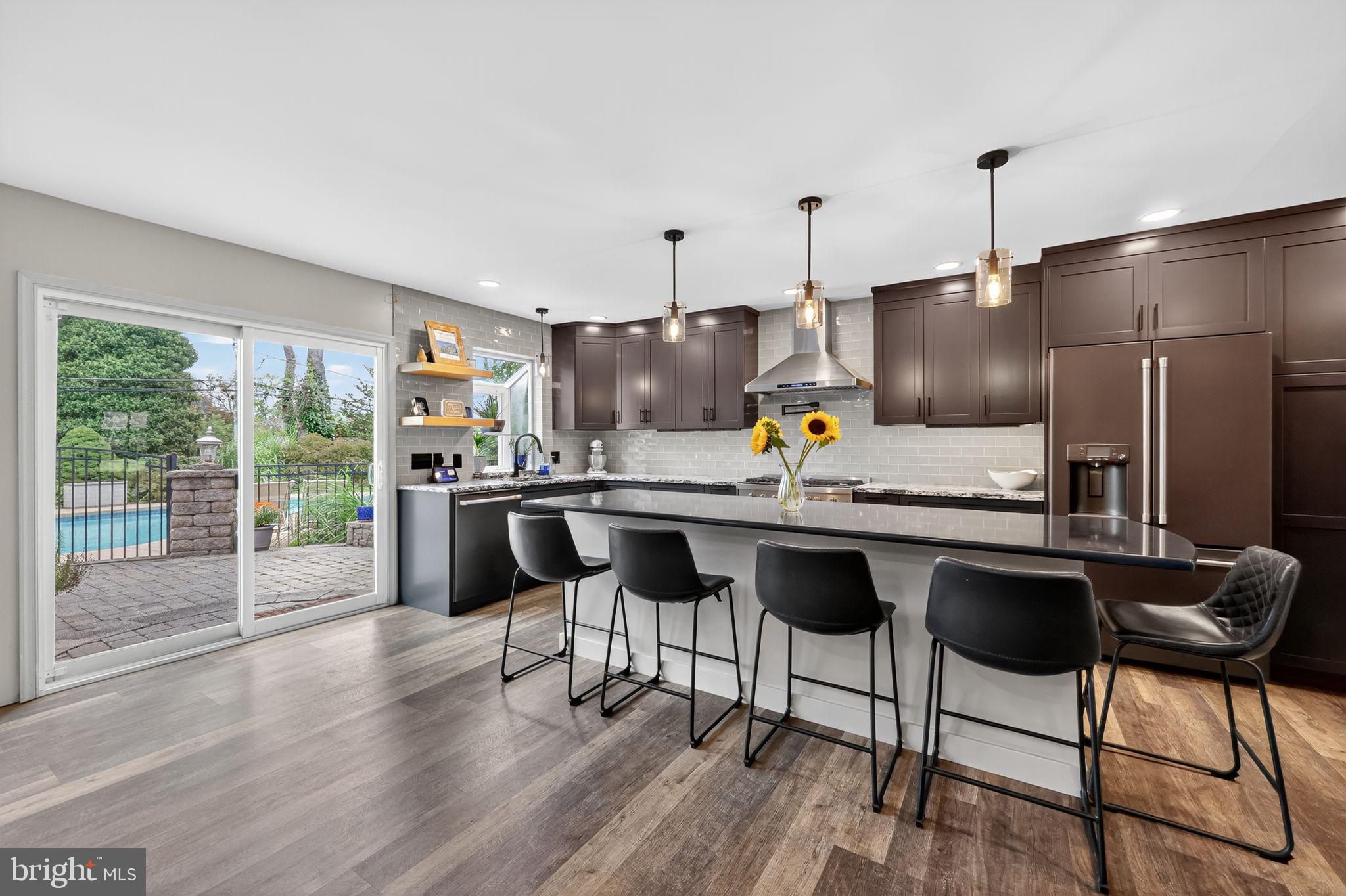 657 Pembroke Road Rydal, PA 19046 - Photo 16 of 36 a kitchen with granite countertop a table chairs stove refrigerator and wooden floor