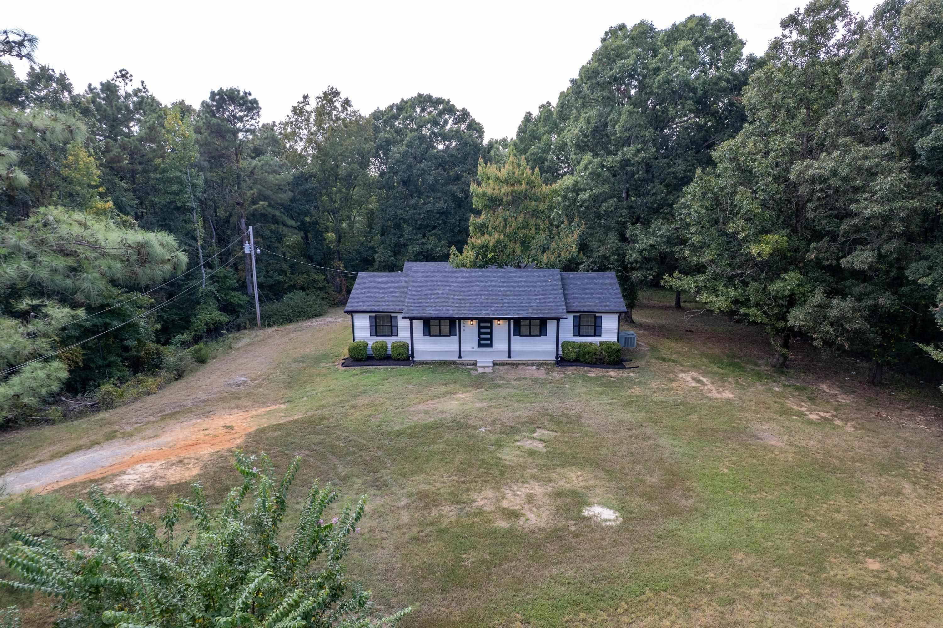 3690 Callahan Road Middleton, TN 38052 - Photo 26 of 26 White exterior with dark trim, dark shingle roof, and a mature tree line backdrop