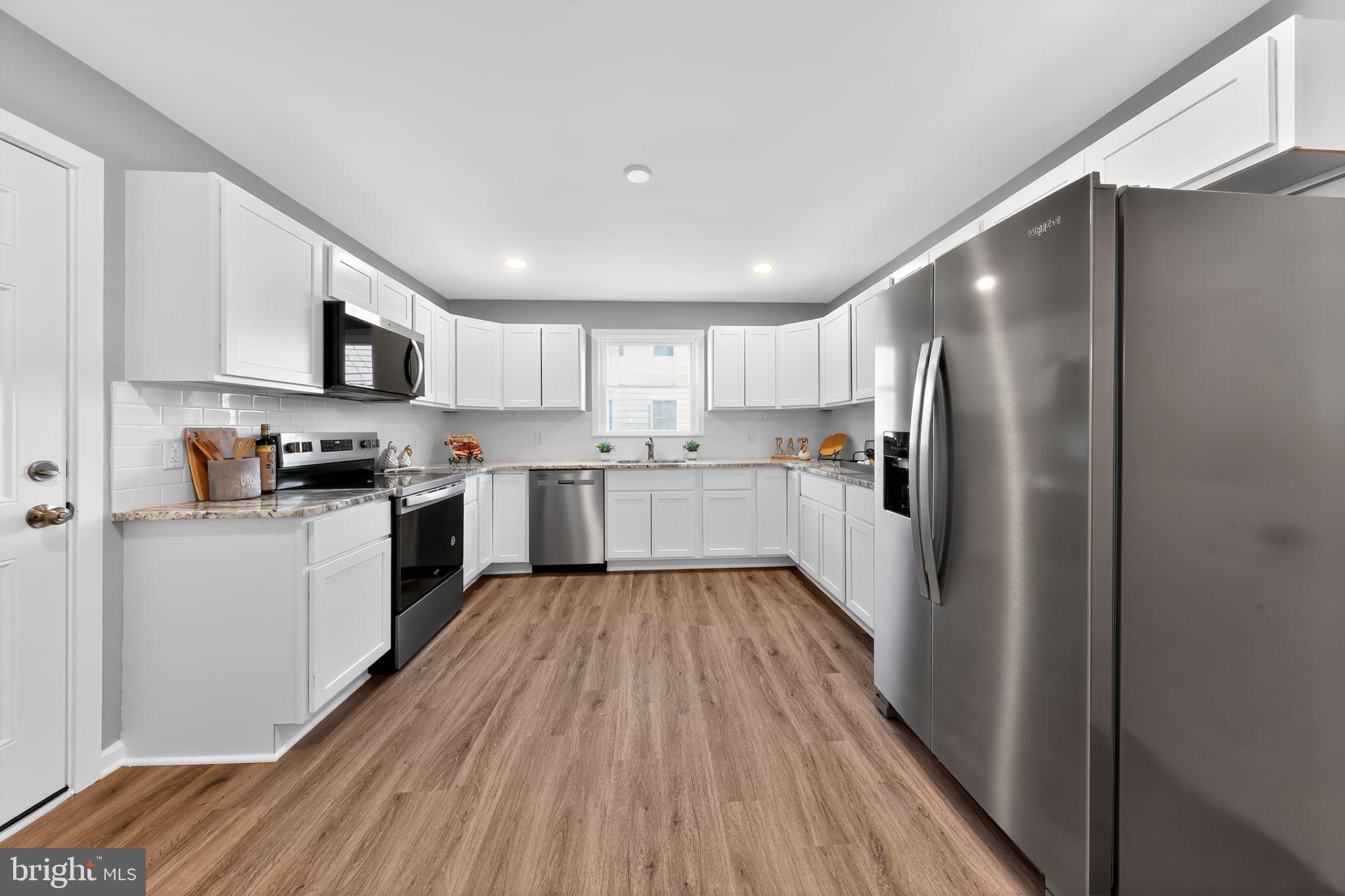261 West Main Street Elkton, MD 21921 - Photo 16 of 31 a kitchen with wooden floors stainless steel appliances and a window