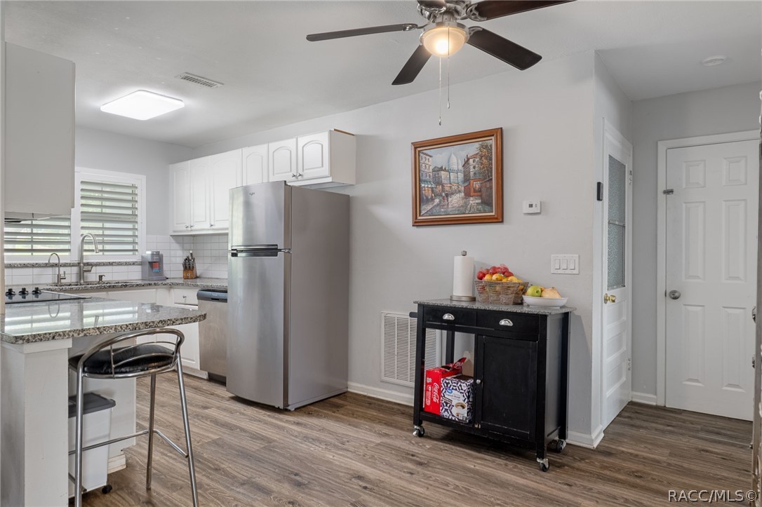1140 South Highlands Avenue Inverness, FL 34452 - Photo 14 of 54 a kitchen with stainless steel appliances a stove refrigerator and cabinets