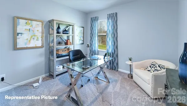 a bedroom with a bed and a lamp on dresser
