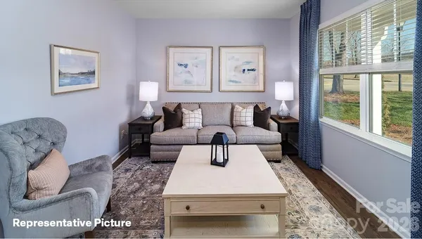 a kitchen with stainless steel appliances granite countertop a dining table chairs refrigerator and microwave