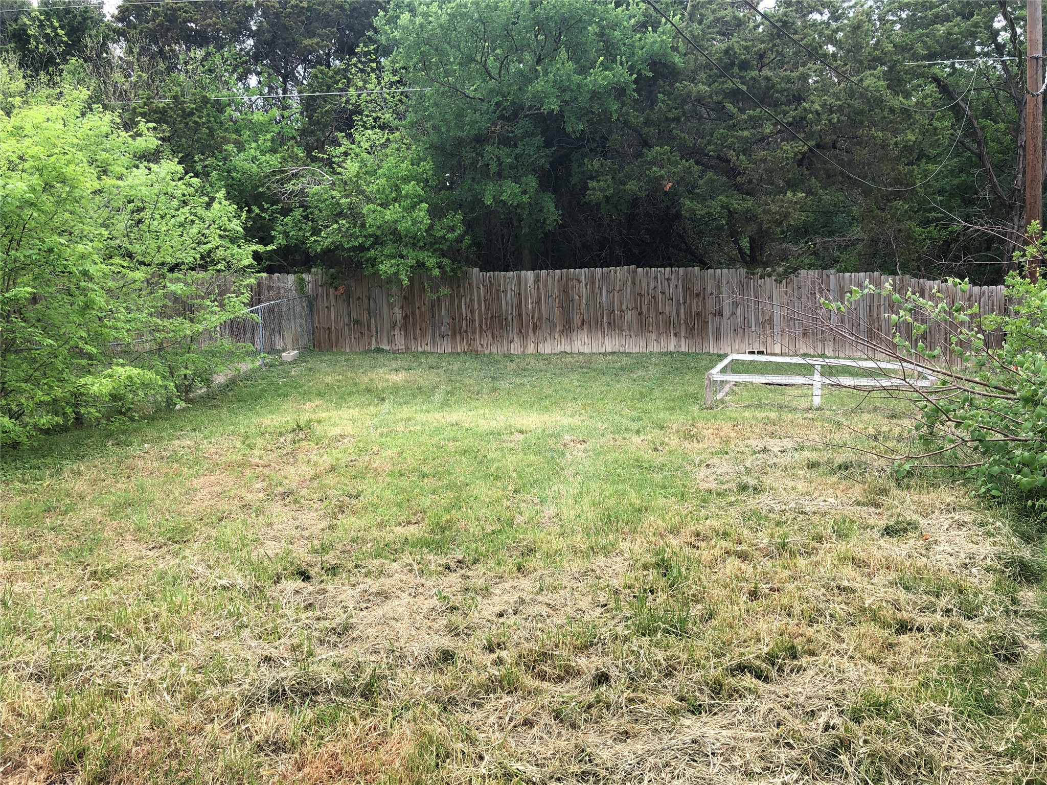 11510 Walnut Ridge Drive, Unit B Austin, TX 78753 - Photo 16 of 18 Mature trees frame a grassy lawn bordered by secure wood fencing.