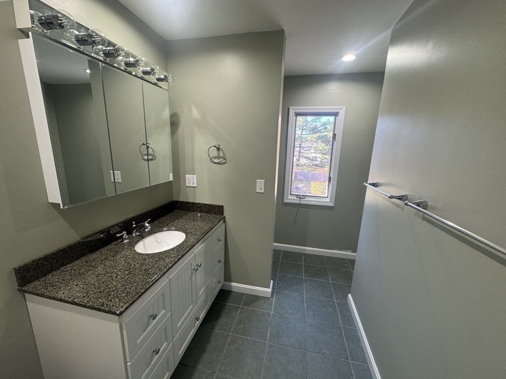 39 Neillian Street, Unit 39 Bedford, MA 01730 - Photo 17 of 29 a bathroom with a granite countertop sink and a mirror