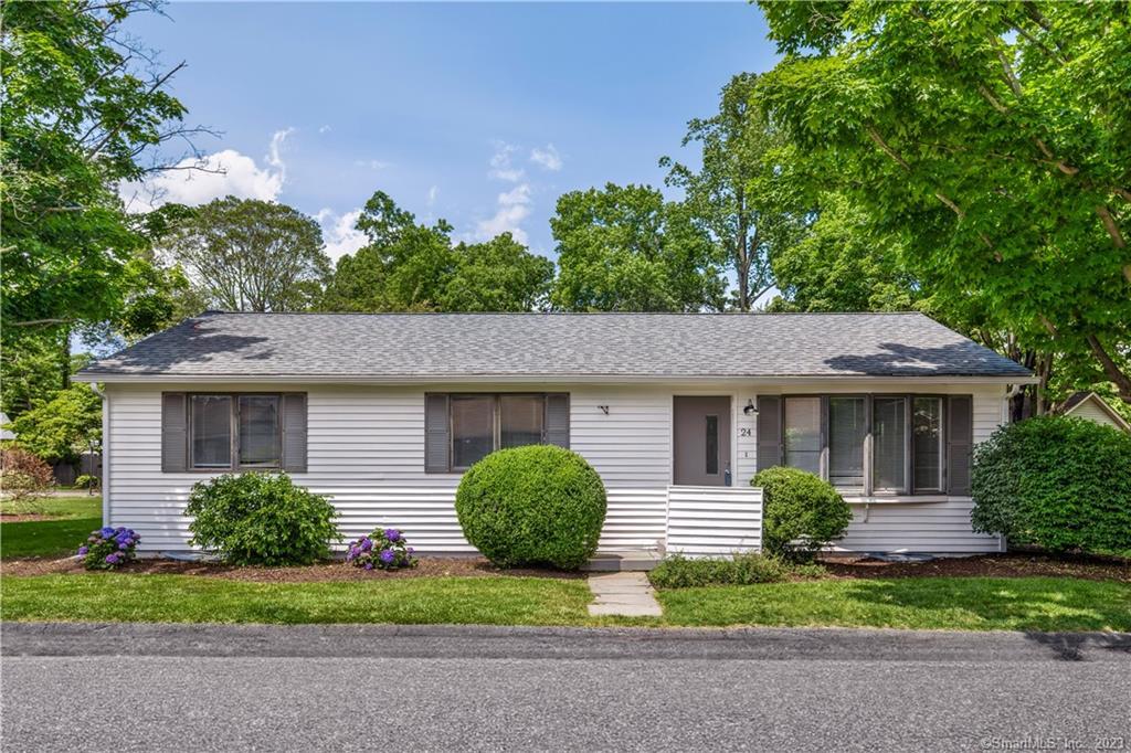 a view of a house with a yard and large tree