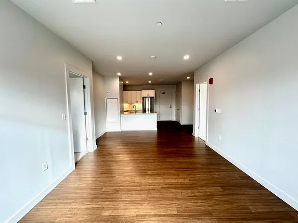 a view of an empty room with wooden floor
