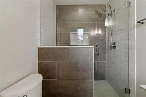 a bathroom with a toilet and a shower