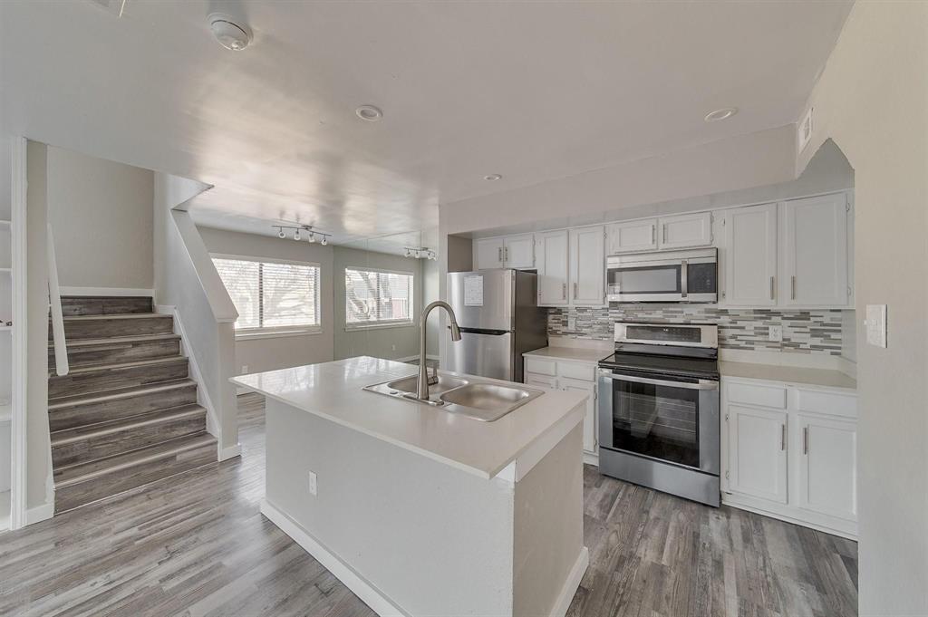9815 Walnut Street, Unit 210 Dallas, TX 75243 - Photo 6 of 11 a kitchen with stainless steel appliances kitchen island granite countertop a sink stove and refrigerator