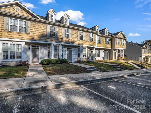 a front view of a house with yard and parking