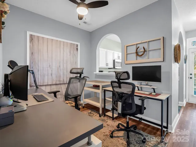 a view of a workspace with furniture and a window