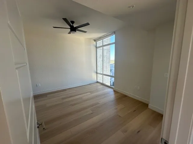 a view of a livingroom with wooden floor and a ceiling fan