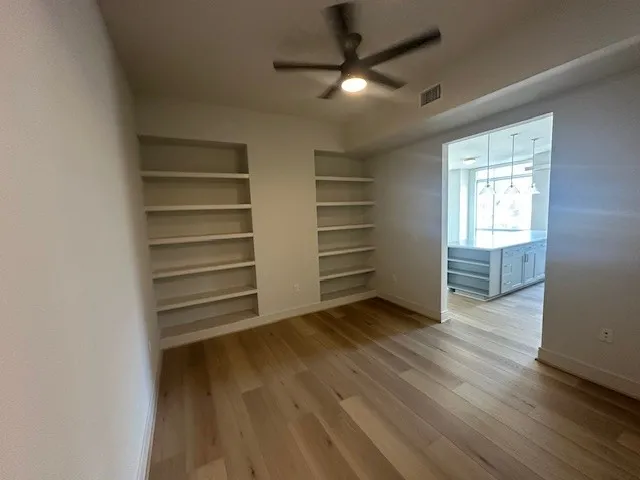 a view of a room with wooden floor closet and windows