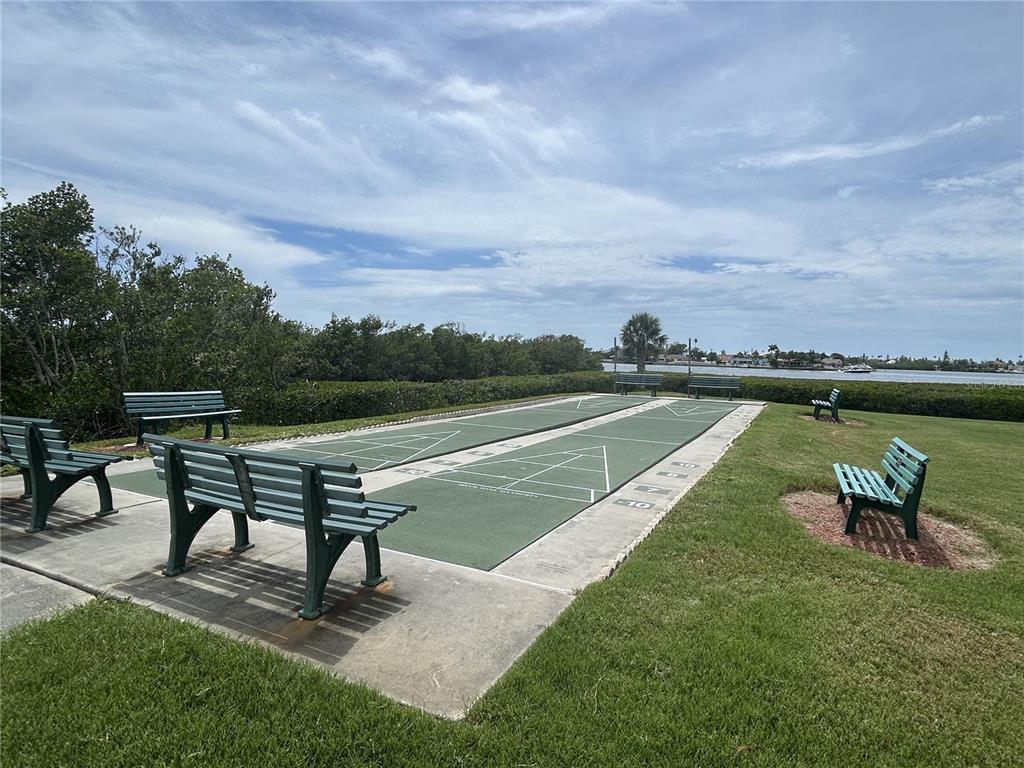 12760 Indian Rocks Road, Unit 904 Largo, FL 33774 - Photo 30 of 40 a swimming pool with outdoor seating and wooden fence