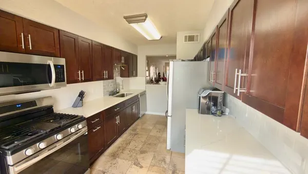 a large kitchen with a stove a sink and a microwave