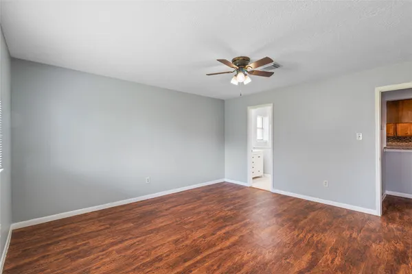 a view of a big room with wooden floor and a ceiling fan