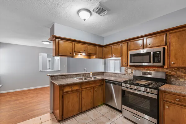a kitchen with stainless steel appliances granite countertop a stove and a sink