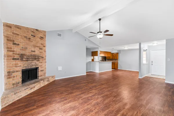 a view of empty room with wooden floor and fireplace