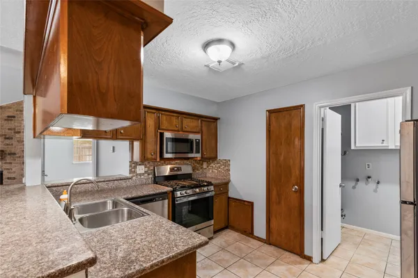 a kitchen with stainless steel appliances granite countertop a sink stove and refrigerator