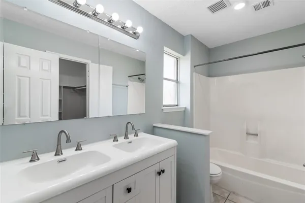 a bathroom with a sink double vanity granite tub and a mirror