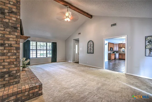 a view of a kitchen with furniture and a refrigerator