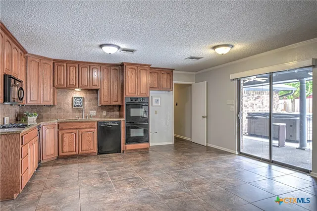 a kitchen with stainless steel appliances granite countertop a refrigerator stove top oven and sink