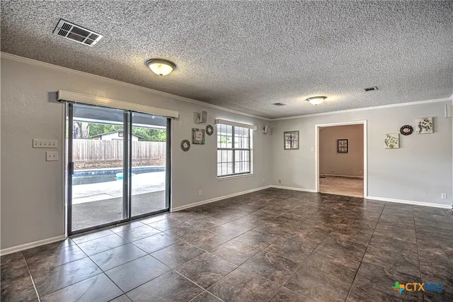 an empty room with windows and fan