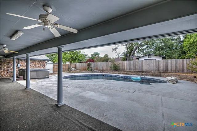 a view of house with a swimming pool and sitting area