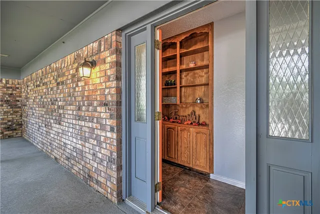 an empty room with windows and fireplace