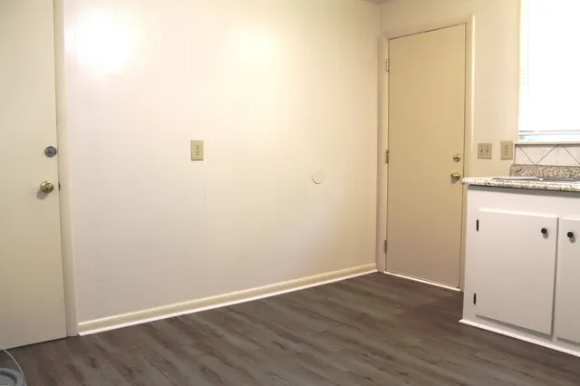 an empty room with wooden floor and a window