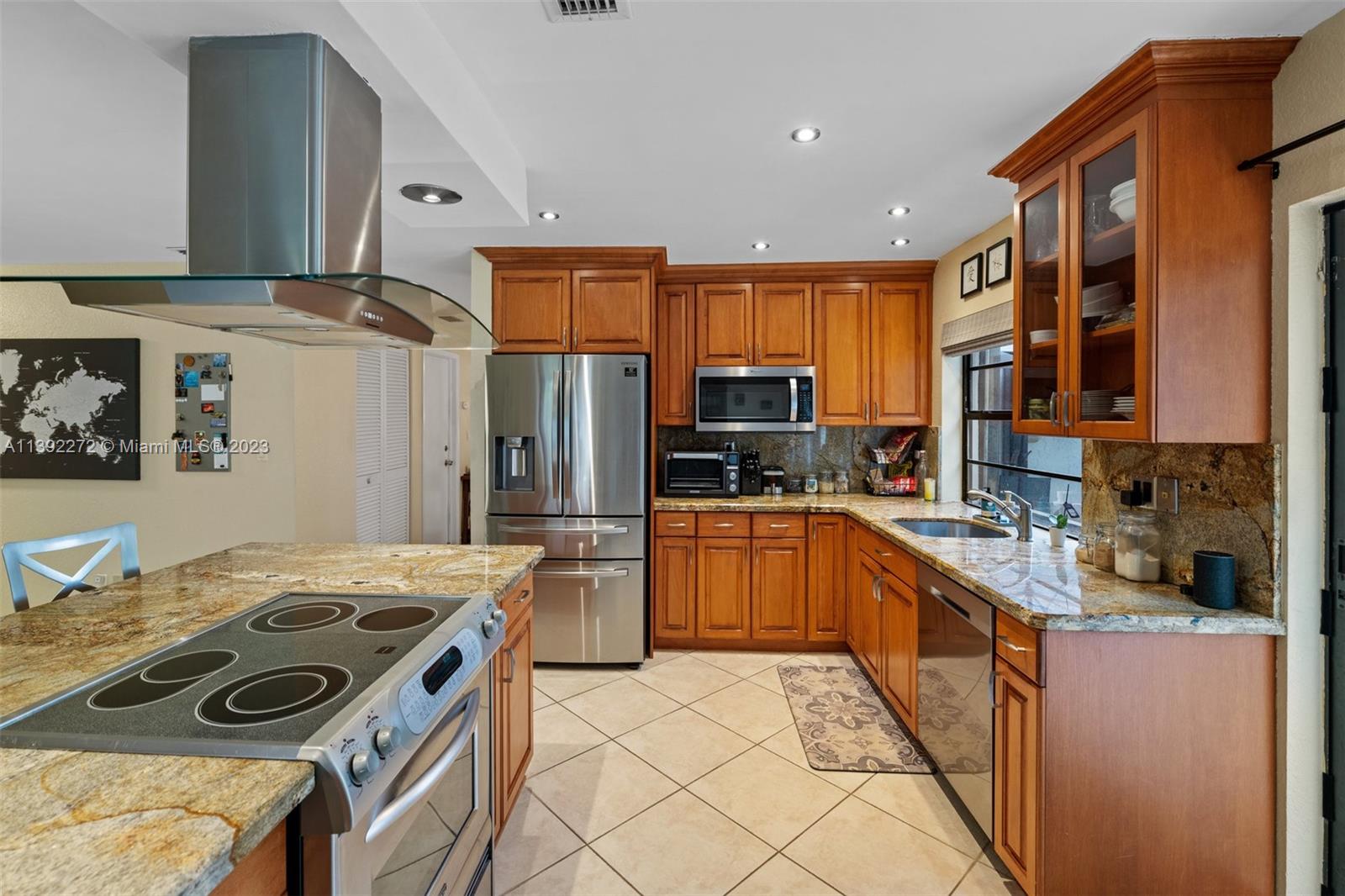 28 Cedar Road Hollywood, FL 33021 - Photo 7 of 43 a kitchen with stainless steel appliances granite countertop a stove top oven a sink a refrigerator and white cabinets
