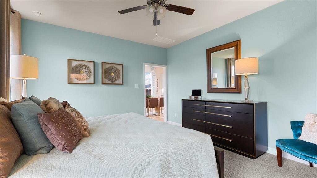 117 Hugo Court Rhome, TX 76078 - Photo 18 of 39 a bedroom with a bed and a chandelier