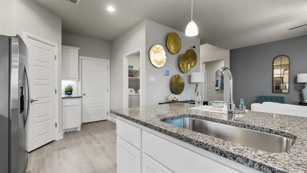117 Hugo Court Rhome, TX 76078 - Photo 6 of 39 a kitchen with stainless steel appliances granite countertop a sink a stove and a wooden floors