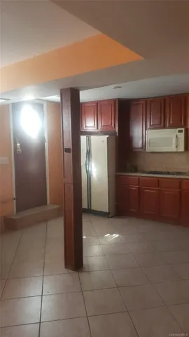 a view of a kitchen with an empty room and cabinets