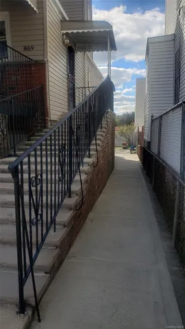 a view of a pathway of a house with wooden fence