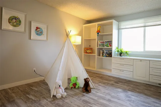a view of a bedroom with wooden floor and windows