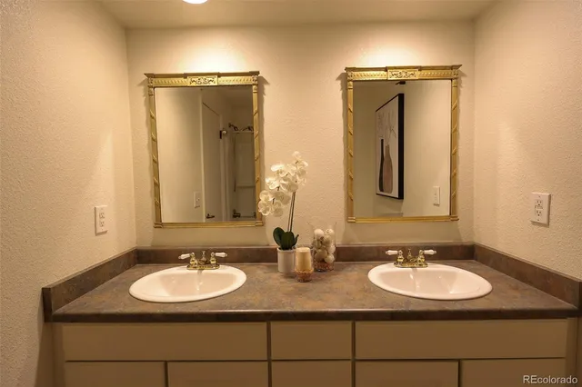 a bathroom with double sink and a mirror