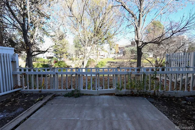 a view of a house with a small yard and wooden fence
