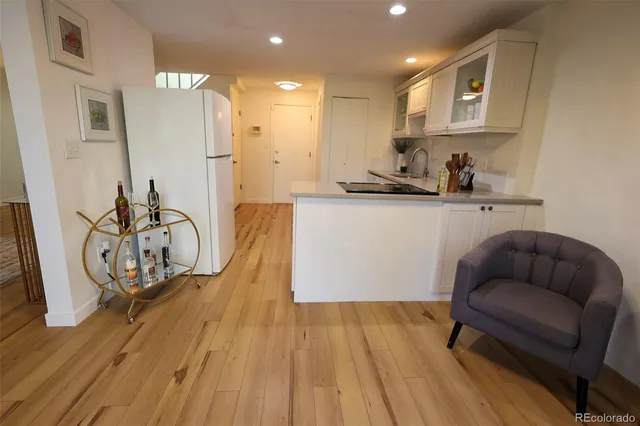 a kitchen with stainless steel appliances granite countertop a refrigerator a stove a sink and a wooden floors