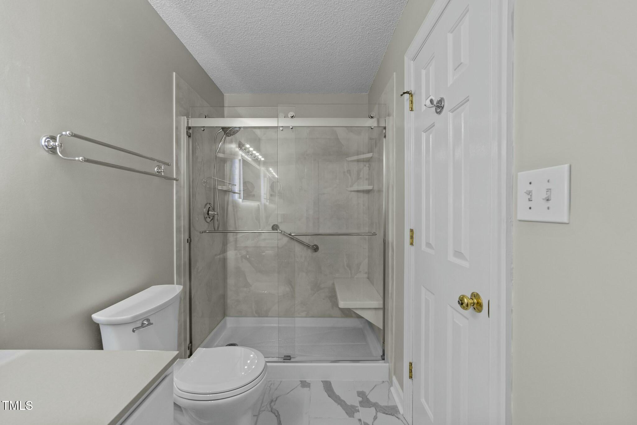 1234 Shadow Bark Court Raleigh, NC 27603 - Photo 26 of 36 a bathroom with a shower a toilet and a glass door