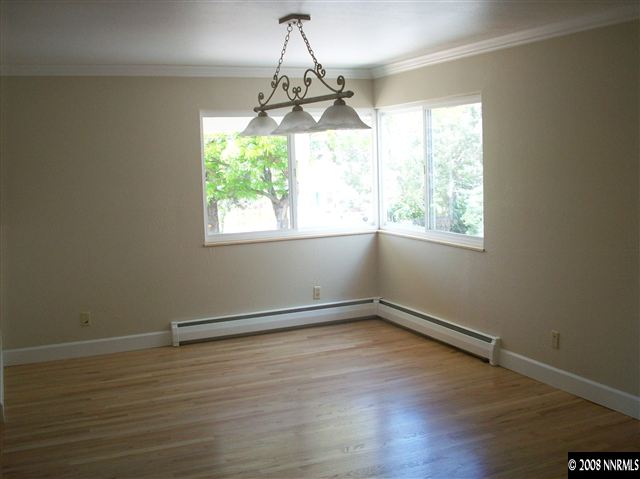 14440 Virginia Foothills Drive Reno, NV 89521 - Photo 4 of 9 an empty room with wooden floor and windows