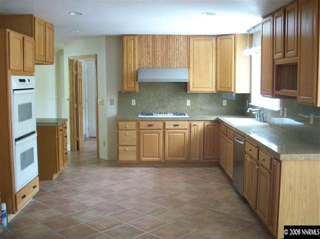 14440 Virginia Foothills Drive Reno, NV 89521 - Photo 5 of 9 a large kitchen with cabinets and stainless steel appliances