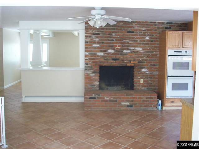 14440 Virginia Foothills Drive Reno, NV 89521 - Photo 6 of 9 a view of an empty room and kitchen with fireplace