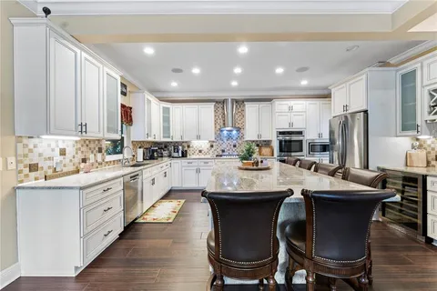 a kitchen with granite countertop white cabinets and chairs